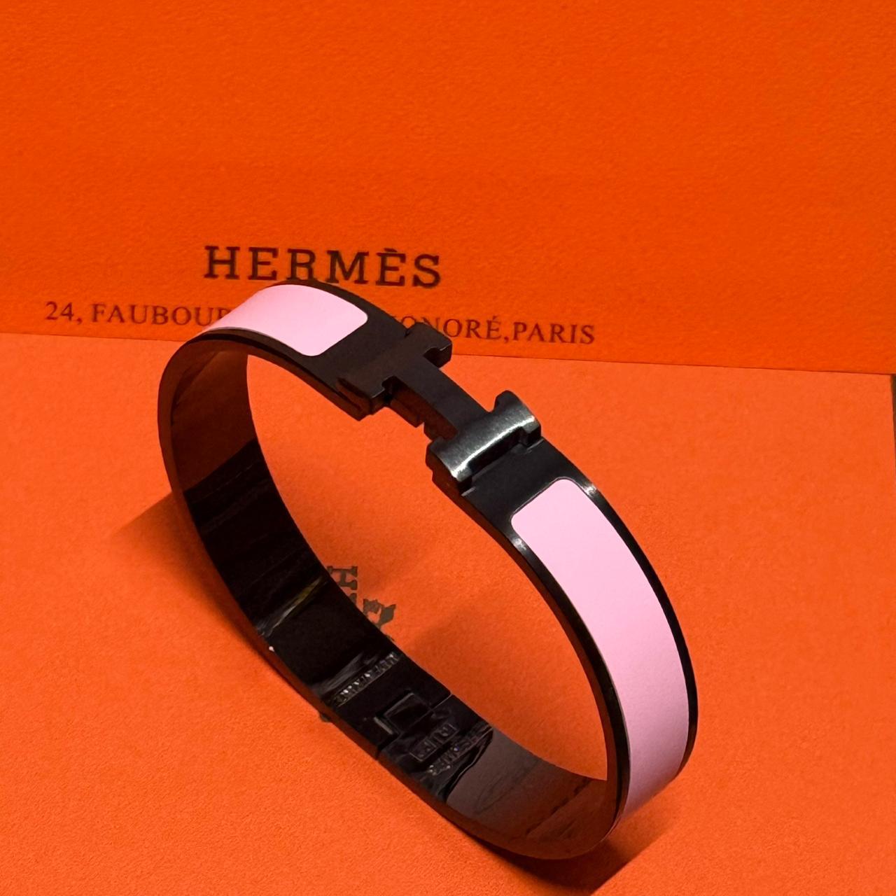 Hermes bracelet on an orange background with brand name visible