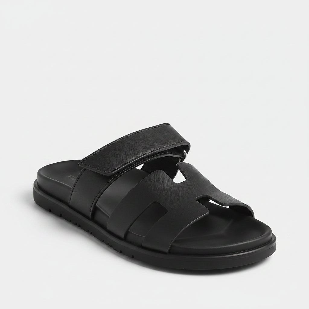 Black sandal with a prominent 'H' logo on a light white background