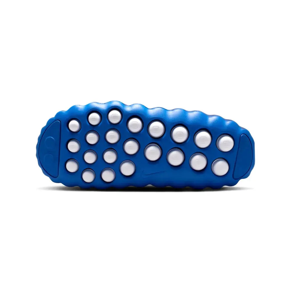 Blue textured object with white dots on a white background