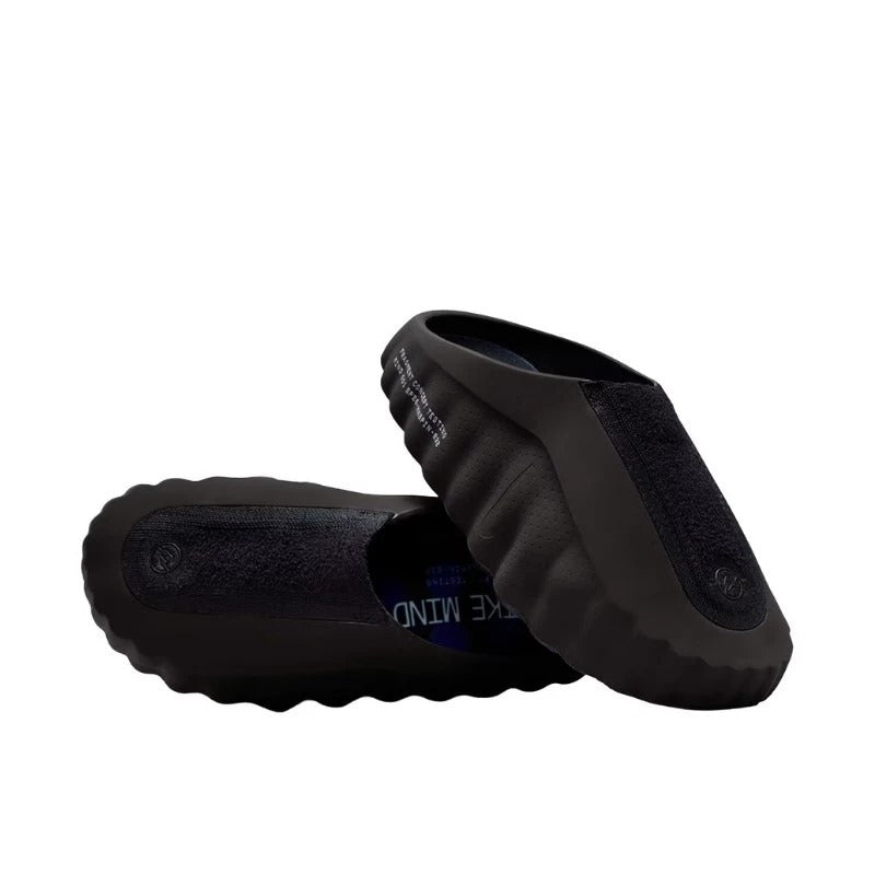 Black rubber shoes with textured sole on a white background