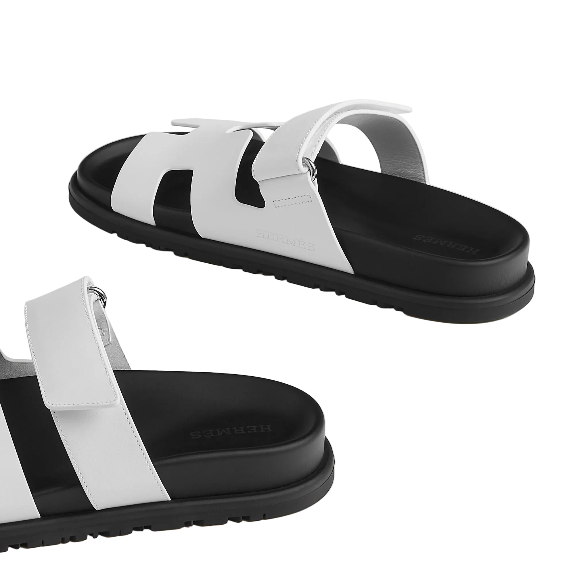 White and black sandals with a minimalistic design on a light white background