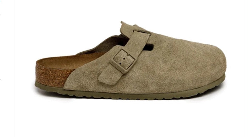 Beige suede clog shoe with a brown sole on a white background