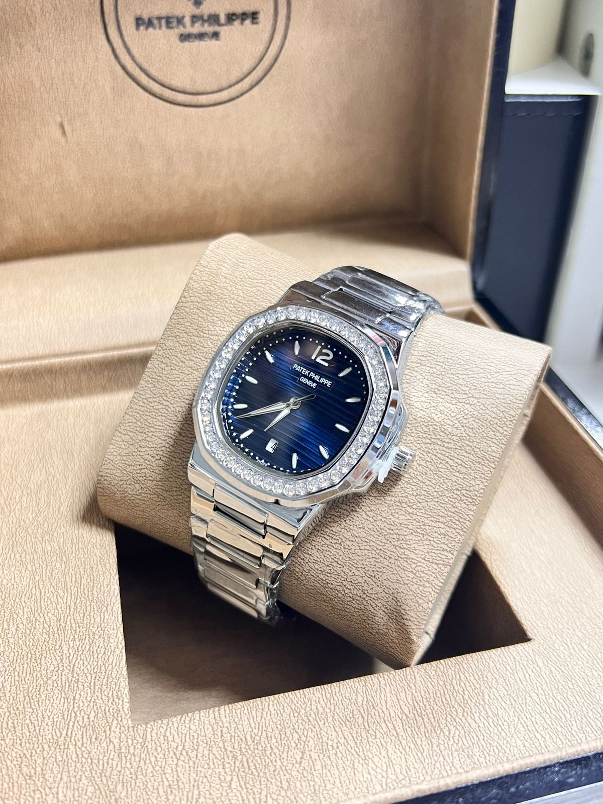 Luxury watch with blue dial and diamond-studded case in Patek Philippe box
