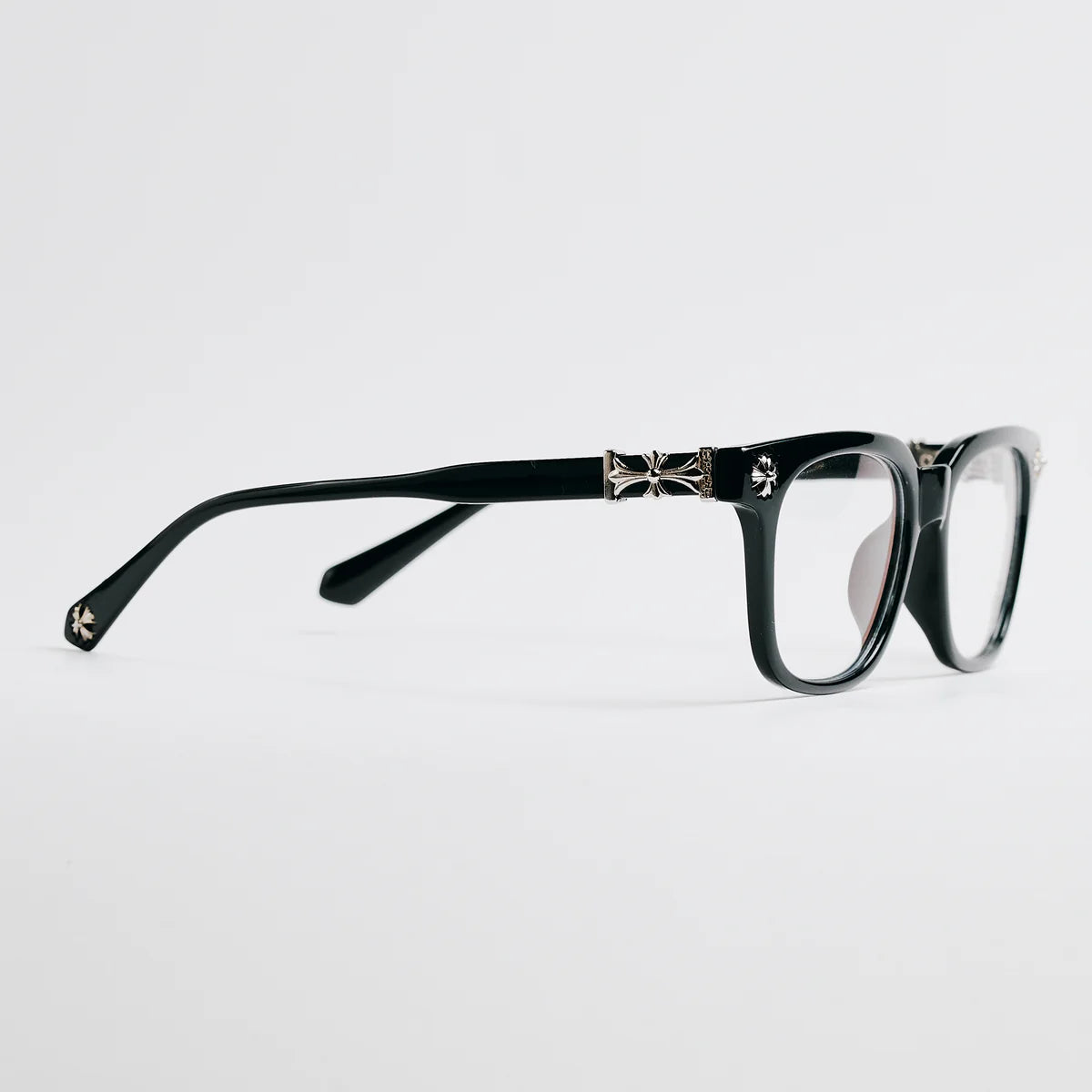 Black eyeglasses with decorative elements on a light gray background