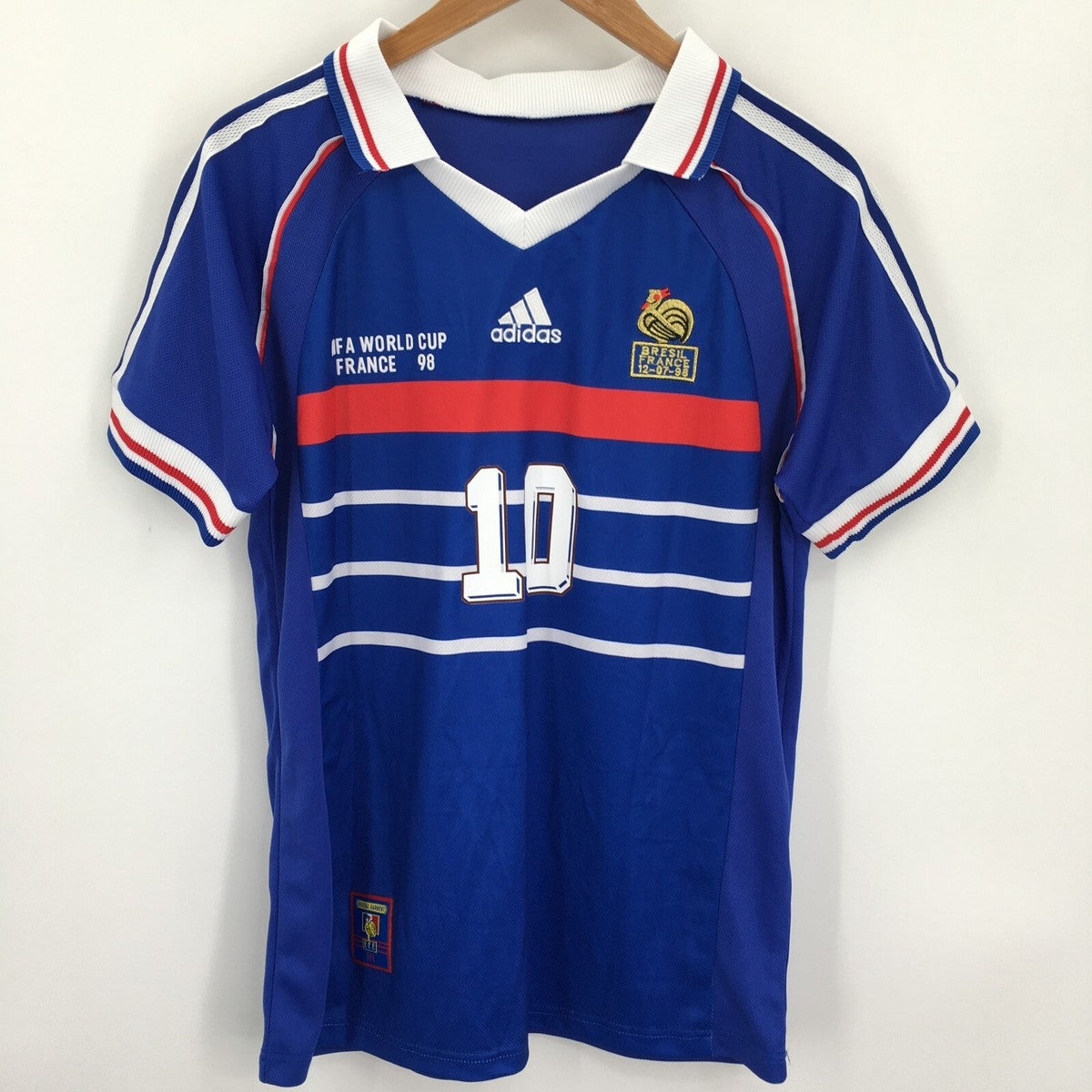 Blue sports jersey with white and red accents, featuring Adidas logo and World Cup France 98 text.